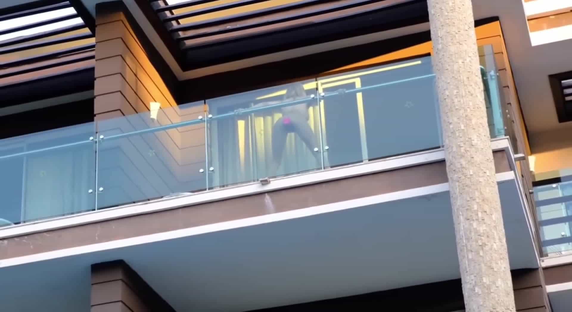 Masturbating in full view from her balcony