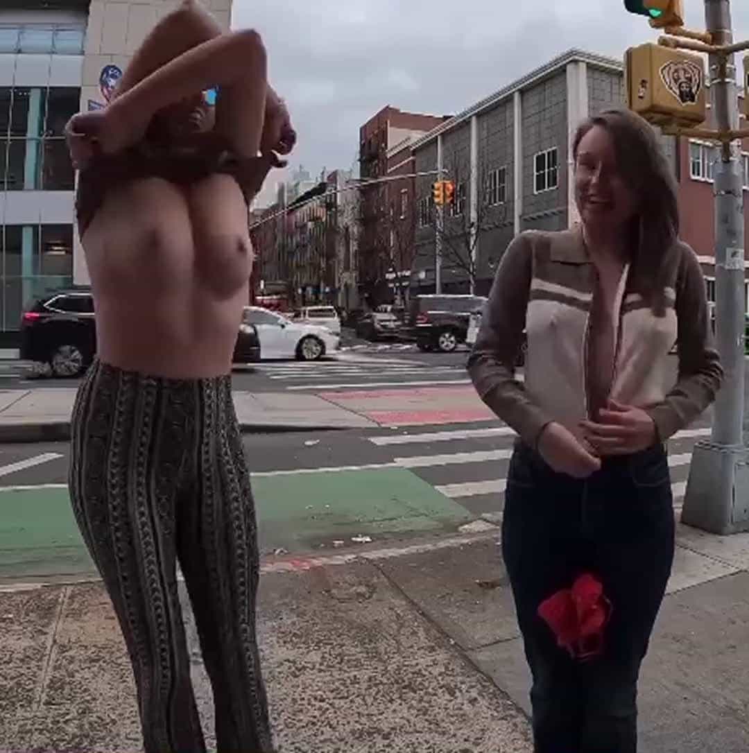 Two babes going topless in the street 